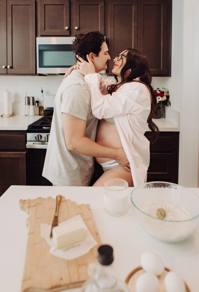 in home maternity session in the kitchen, couple hugging in calvin klein underwear with eggs, butter and milk nearby to make pancakes for breakfast