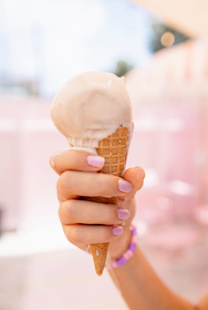 gelato ice cream in a child's hand dripping down the cone